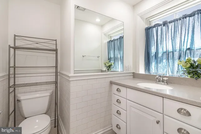 a bathroom with a granite countertop toilet sink and mirror