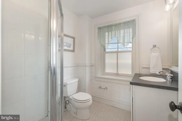a bathroom with a granite countertop toilet sink and mirror