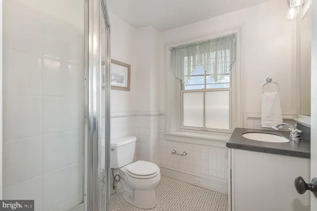 a bathroom with a granite countertop toilet sink and mirror