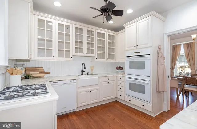 a kitchen with white cabinets and white appliances