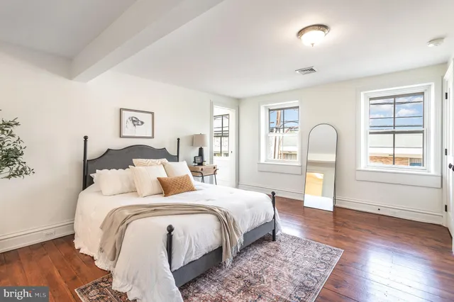 a bedroom with a bed and wooden floor