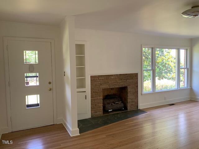 1003 Summerville Mamers Road Lillington, NC 27546 - Photo 2 of 44 an empty room with wooden floor fireplace and windows