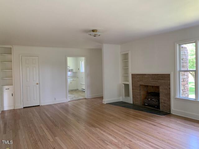 1003 Summerville Mamers Road Lillington, NC 27546 - Photo 3 of 44 an empty room with wooden floor fireplace and windows