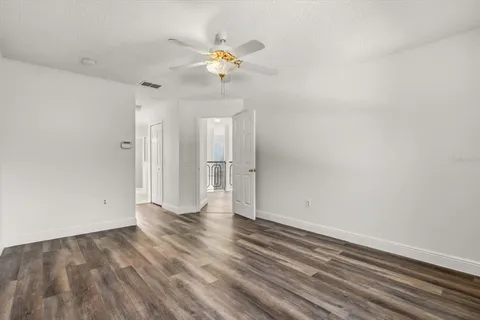 a view of an empty room and chandelier fan