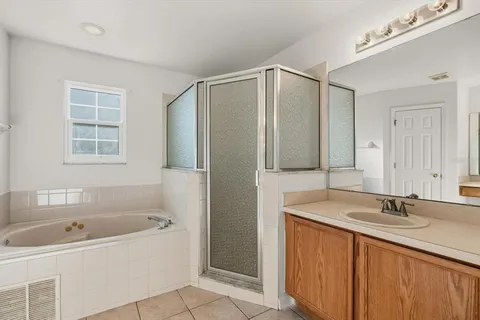 a bathroom with a tub sink and mirror