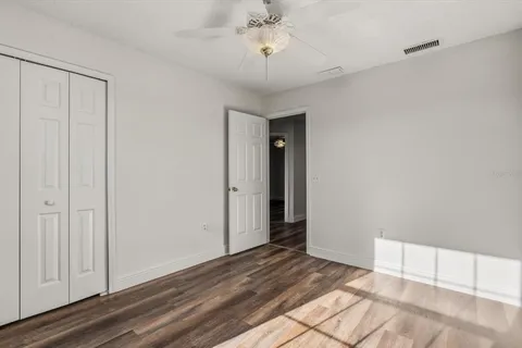 a view of a room with wooden floor and a ceiling fan
