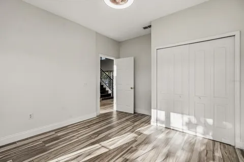 a view of a room with wooden floor and a bathroom