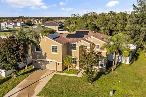 an aerial view of residential houses with outdoor space and trees