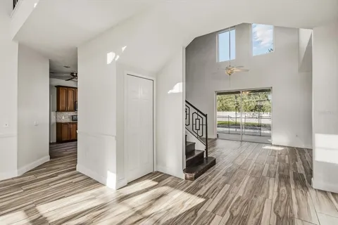 a view of a hallway with wooden floor and a bathroom