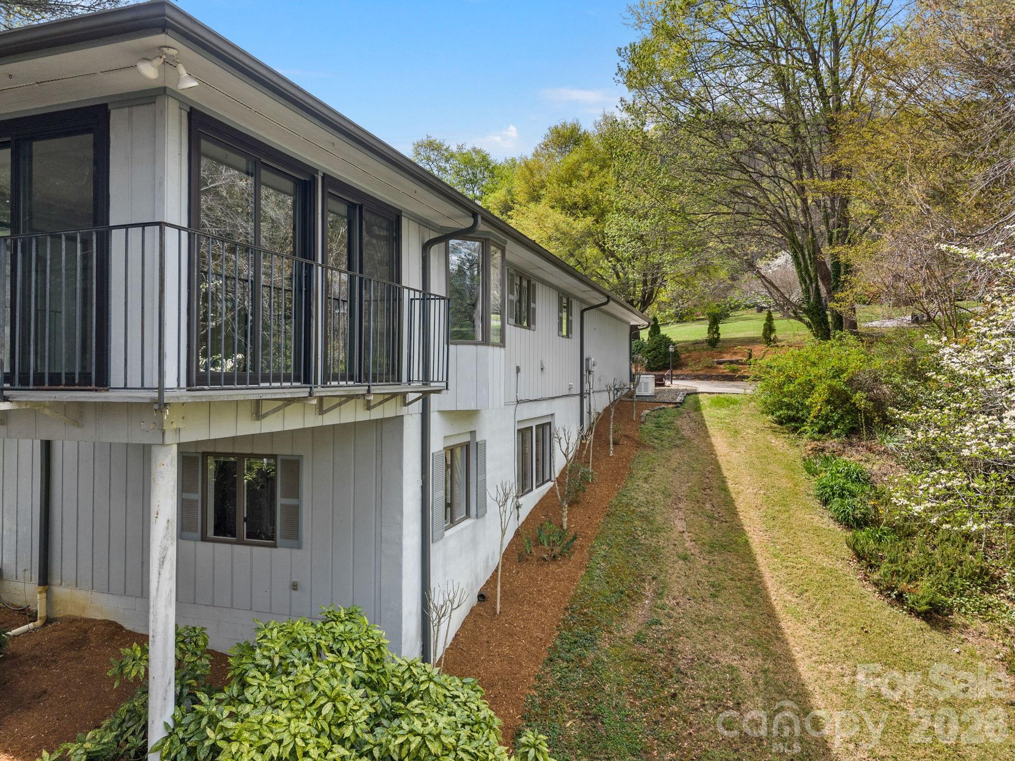140 Meadowlark Drive Tryon, NC 28782 - Photo 42 of 45 a view of a house with large windows and a small yard