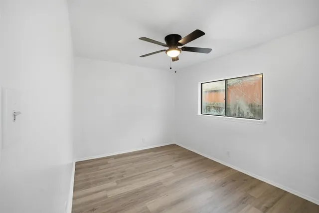 a view of a big room with wooden floor and windows