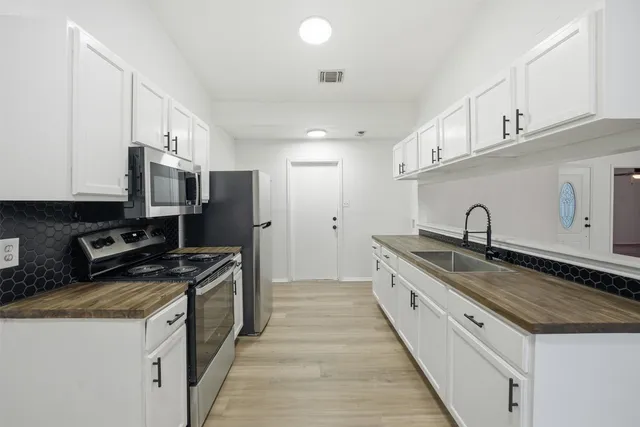 a kitchen with stainless steel appliances granite countertop a stove a sink and a refrigerator