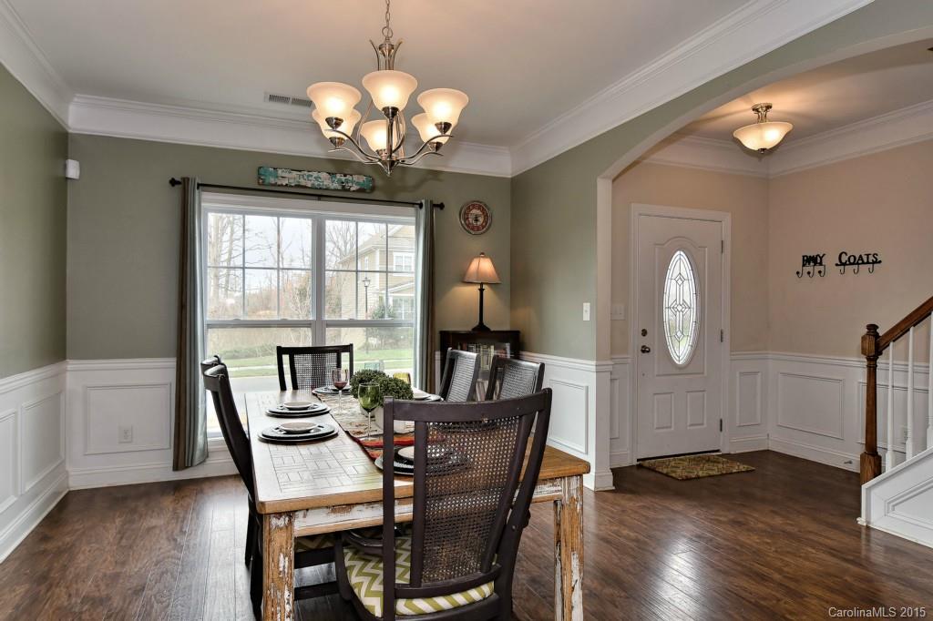 1004 Ridgehaven Road Waxhaw, NC 28173 - Photo 3 of 24 a dining room with wooden floor a chandelier a wooden table and chairs