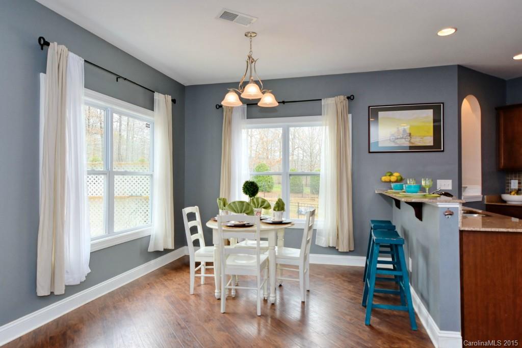1004 Ridgehaven Road Waxhaw, NC 28173 - Photo 6 of 24 a dining room with wooden floor a chandelier a wooden table and chairs