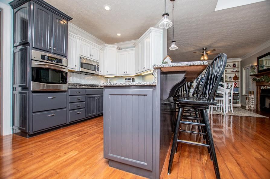 575 Liberty Church Road Carrollton, GA 30116 - Photo 16 of 95 a kitchen with stainless steel appliances granite countertop a stove top oven a sink dishwasher and a refrigerator with wooden floor