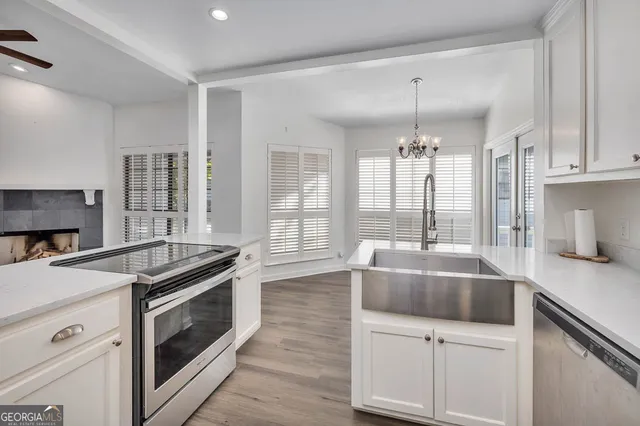 a kitchen with granite countertop a sink cabinets and stainless steel appliances
