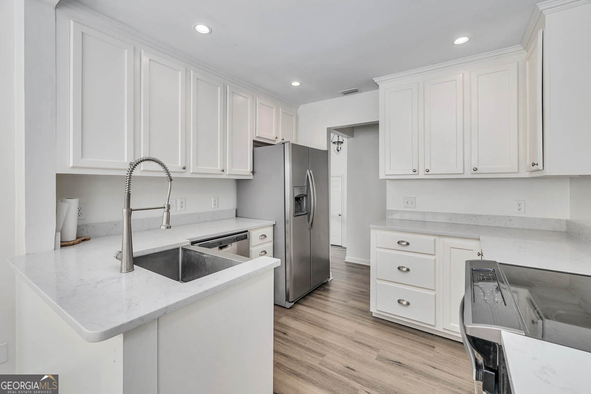 3 Bay Tree Court West St. Simons, GA 31522 - Photo 20 of 36 a kitchen with granite countertop a sink cabinets and stainless steel appliances
