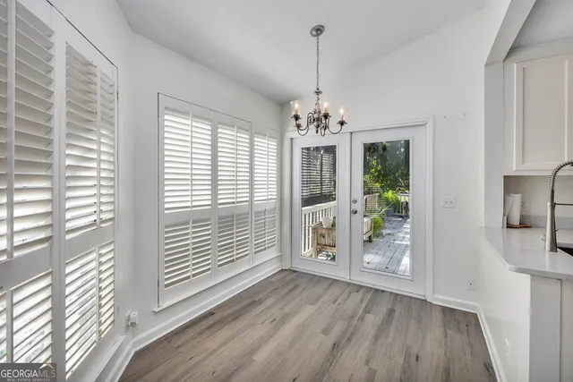 a view of an empty room with wooden floor fireplace and a window