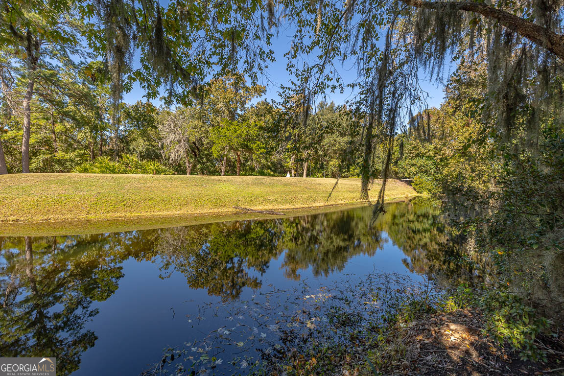 3 Bay Tree Court West St. Simons, GA 31522 - Photo 35 of 36 a view of a lake with a yard and trees all around