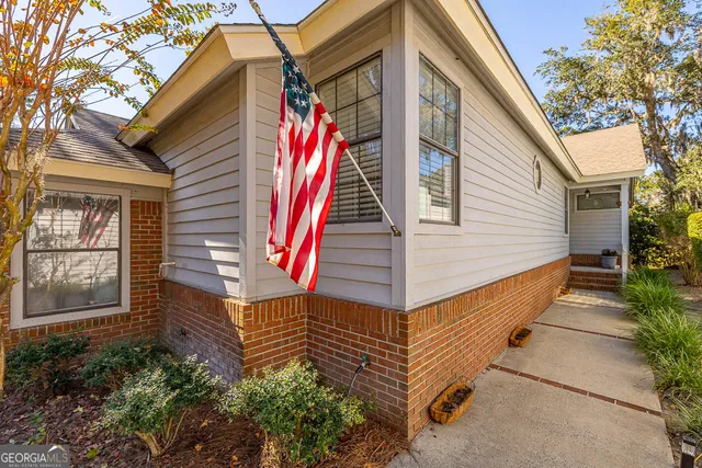 a view of a house with a yard and potted plants