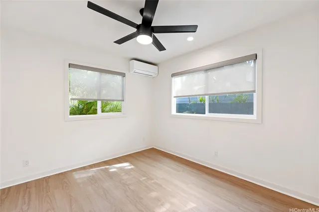 an empty room with a window and ceiling fan