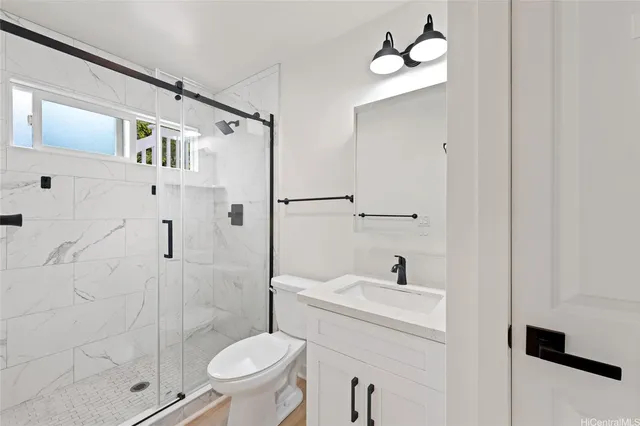 a bathroom with a sink a toilet and shower