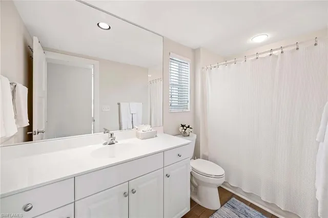 a bathroom with a double vanity sink toilet and a mirror