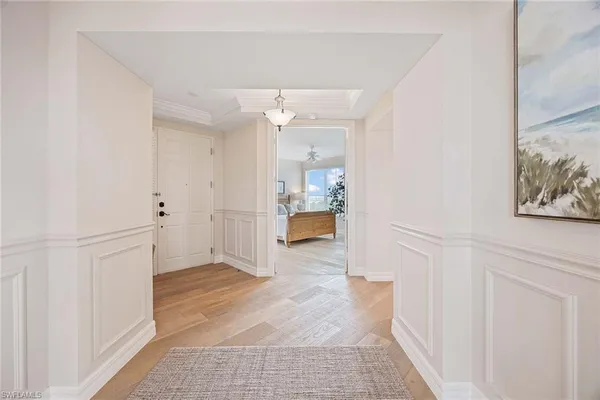 a view of a hallway with wooden floor and a bathroom