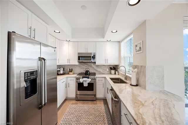 a kitchen with stainless steel appliances granite countertop a refrigerator a stove top oven a sink and dishwasher