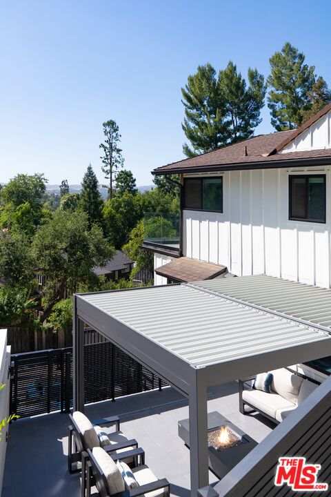 4118 Oak Hollow Road Calabasas, CA 91302 - Photo 29 of 55 a view of a patio with table and chairs with wooden fence