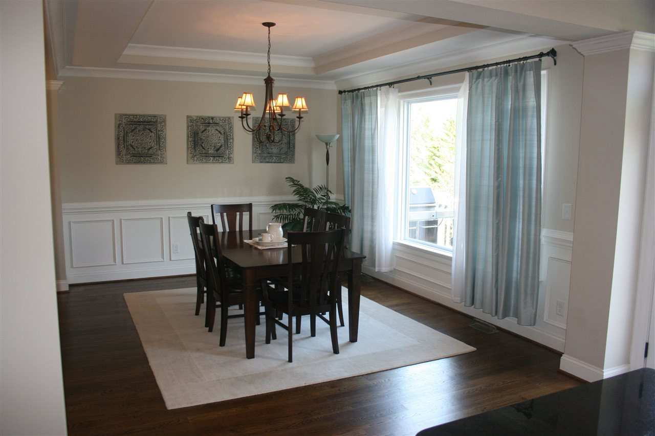 2 Hidden Ridge Court Durham, NC 27707 - Photo 4 of 25 Stately bright and airy, the approximate 15.5' x 11' dining room features hardwood flooring, wainscoting and chair rail, trey ceiling and crown moulding, and looks over the deck. Dining Room