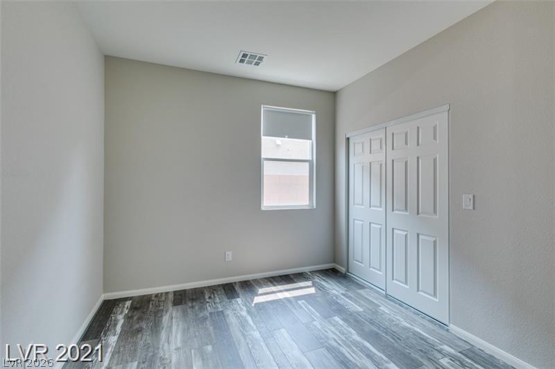 5475 Ordesa Valley Road Las Vegas, NV 89148 - Photo 22 of 35 Natural light filters into this bedroom, featuring sleek wood flooring and ample closet space.