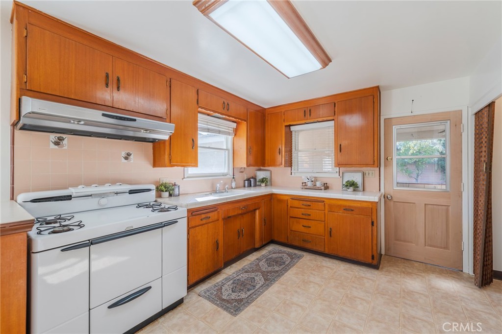 1241 South Walnut Street Anaheim, CA 92802 - Photo 10 of 36 a kitchen with granite countertop cabinets stainless steel appliances a sink and a large window