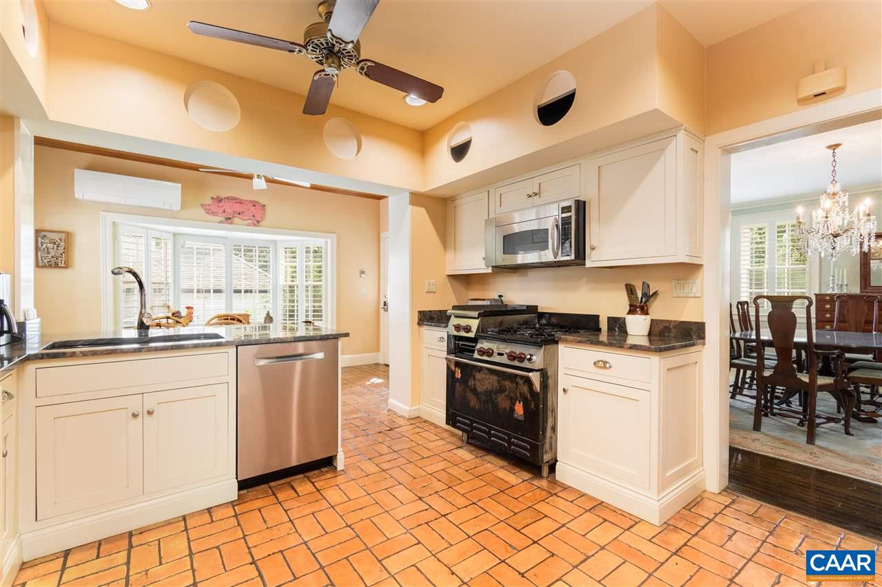 1931 Thomson Road Charlottesville, VA 22903 - Photo 8 of 42 a kitchen with stainless steel appliances granite countertop a stove top oven a sink a dining table and chairs with wooden floor