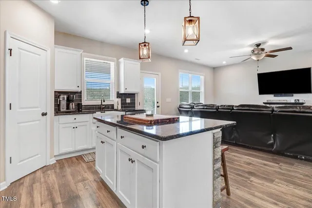 a kitchen with stainless steel appliances a sink a stove a refrigerator cabinets and a window