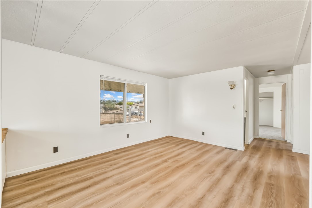 1267 Wilson Road Bullhead City, AZ 86442 - Photo 17 of 37 a view of an empty room with wooden floor and a window