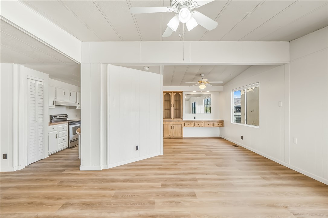 1267 Wilson Road Bullhead City, AZ 86442 - Photo 4 of 37 a view of an empty room with wooden floor and a kitchen