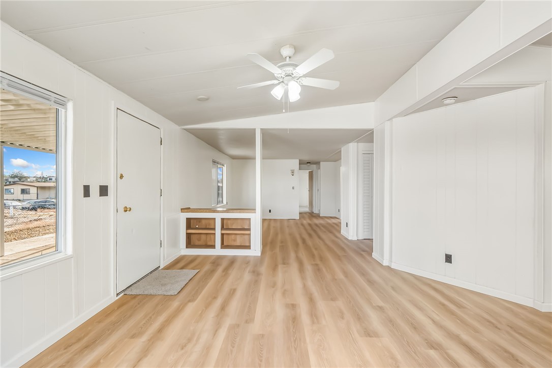 1267 Wilson Road Bullhead City, AZ 86442 - Photo 5 of 37 an empty room with wooden floor ceiling fan and windows
