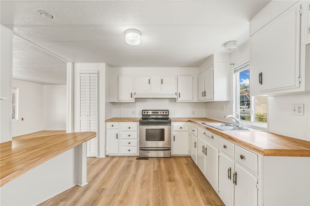 1267 Wilson Road Bullhead City, AZ 86442 - Photo 10 of 37 a kitchen with granite countertop white cabinets and white appliances