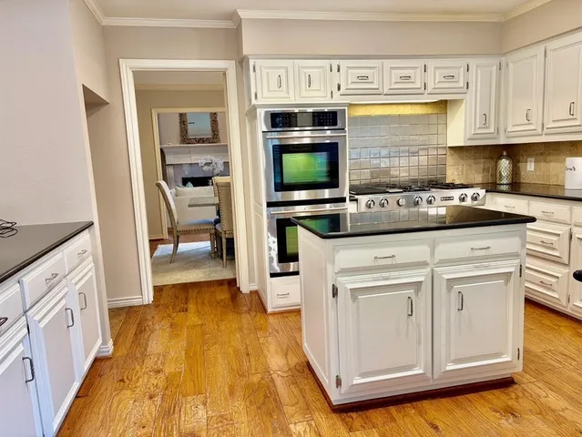 a kitchen with stainless steel appliances granite countertop a stove and a microwave