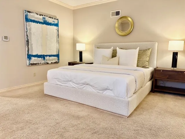 a bedroom with a bed and a painting on the wall