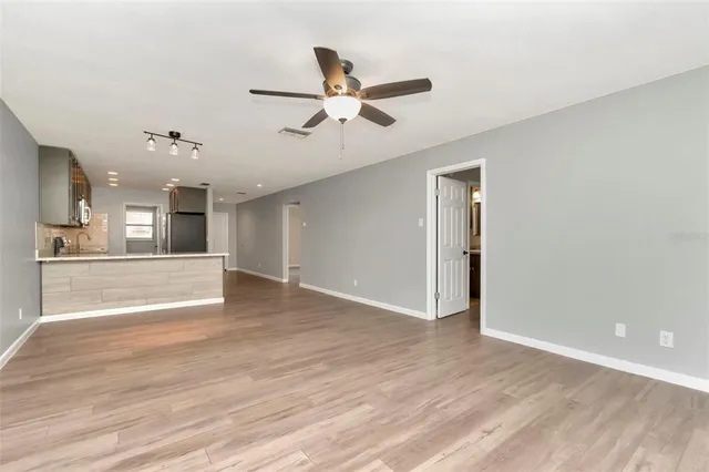 a view of an empty room and kitchen view