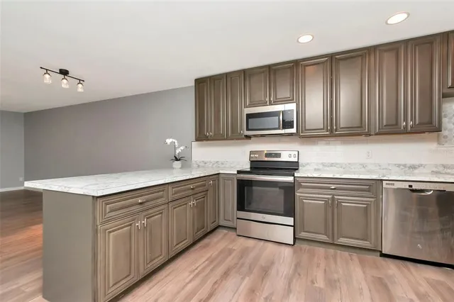 a kitchen with granite countertop wooden cabinets and stainless steel appliances