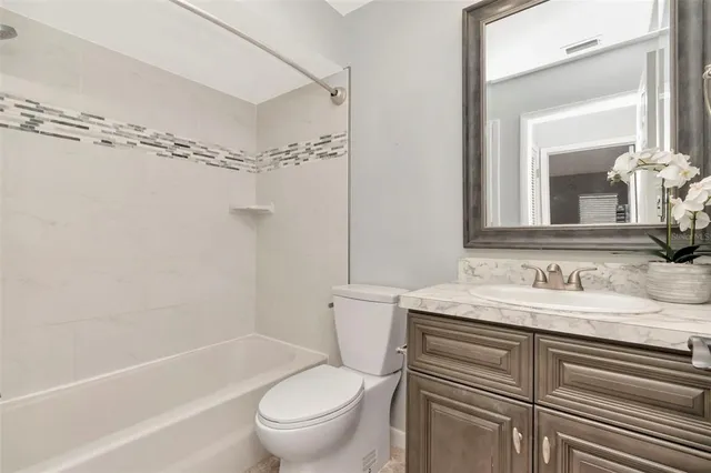 a bathroom with a sink toilet vanity and shower