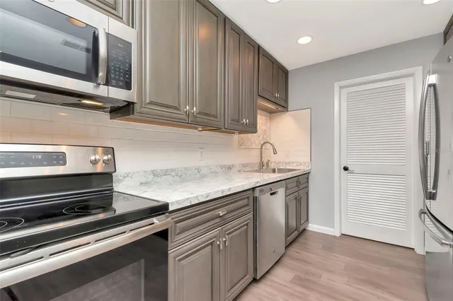 a kitchen with stainless steel appliances granite countertop a stove and a microwave