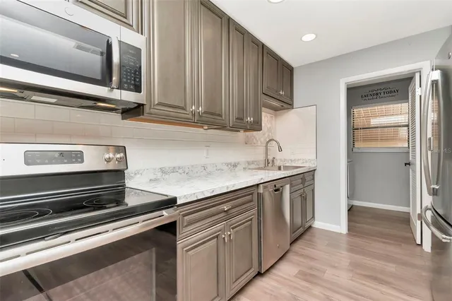 a kitchen with stainless steel appliances granite countertop a sink and a stove