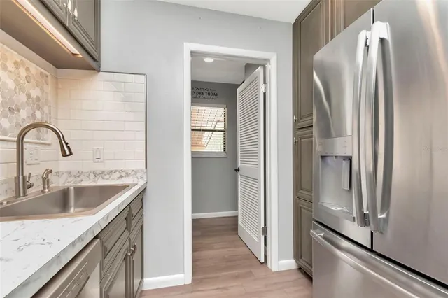 a kitchen with a refrigerator sink and cabinets