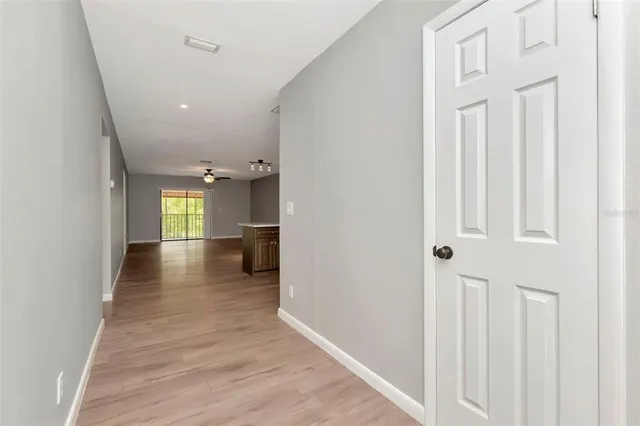 a view of a hallway with wooden floor and staircase