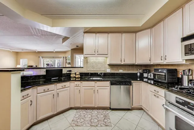 a kitchen with granite countertop a sink and cabinets