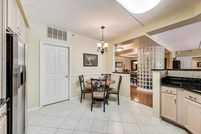 a kitchen with granite countertop cabinets and chairs